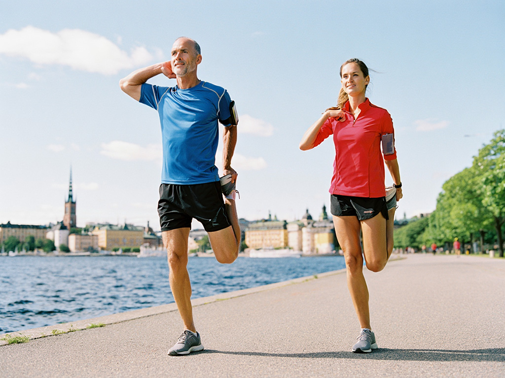 Morgonjoggare som stretchar vid Kungsholmen